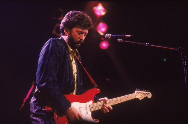 Eric Clapton
‘Slowhand’, who was raised by his grandparents (whom he believed to be his parents) in Surrey, first picked up the guitar at 13. Clapton received inspiration from the Blues masters Robert Johnson , Muddy Waters and Sonny Boy Williamson among others.
Clapton joined the Yardbirds in the early 60s to later briefly join John Mayall & the Bluesbreakers. Later, he was at the vanguard of the British blues scene in the pre-metal psychedelic power trio Cream with bassist Jack Bruce and drummer Ginger Baker. Though he made a transition from heavy and fuzzy to smooth, resonant, mellower and soulful tones, ditching his wah-wah pedal, Clapton remains one of the most respected guitarists in the world.