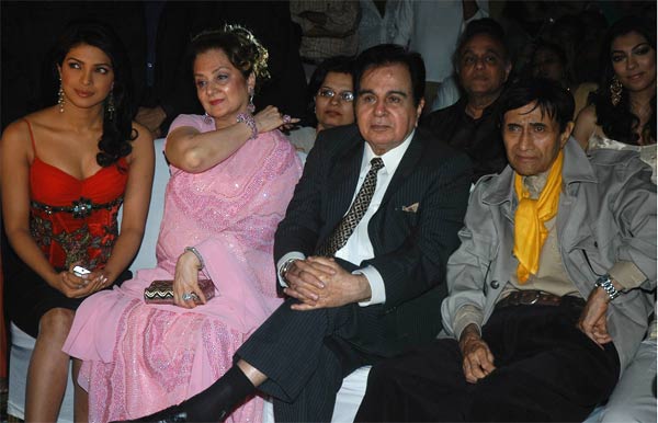 The 88-year-old versatile actor-filmmaker, who passed away in London last night, will be remembered for his swagger, which continue to find imitations till date.
When his contemporaries like Raj Kapoor and Dilip Kumar stopped playing the leading men in movies, Dev Anand did not lose his innate romantic spirit and continued to woo his young heroines with trademark puff of hair, his sloping walk and smile in movies like Johnny Mera Naam, Des Pardes, Hare Rama Hare Krishna among others.
In the pic: (L-R) Dev Anand, Dilip Kumar, Saira Banu and Priyanka Chopra
(DNA)
