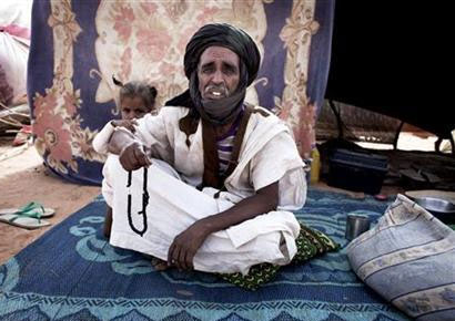Moulay Mohamed, 55, and his daughter Katita Neneh pose for a picture on a carpet in front of their shelter at Mbera refugee camp in southern Mauritania.