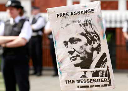 Police and protesters wait for Wikileaks founder Julian Assange to speak to the media outside the Ecuador embassy