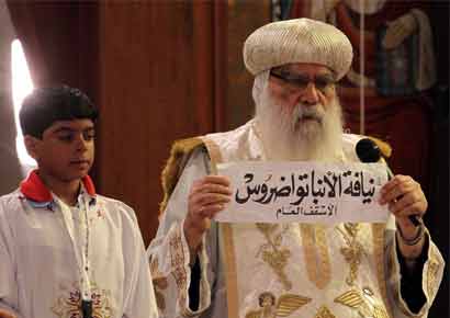 Egyptian caretaker of the Coptic Church, interim Pope Bakhomious (R) holds a piece of paper with the name of Bishop Tawadros written on it, after it was picked by Bishoy Gerges in Cairo