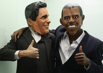 Actors wearing Mitt Romney (L) and Barack Obama masks stand in an elevator while attending a U.S. election party at the Bertelsmann Foundation on November 6, 2012.