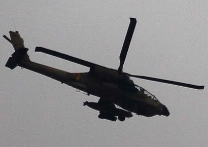 An Israeli Apache helicopter flies over the border between Israel and the northern Gaza Strip in this November 11 file photo