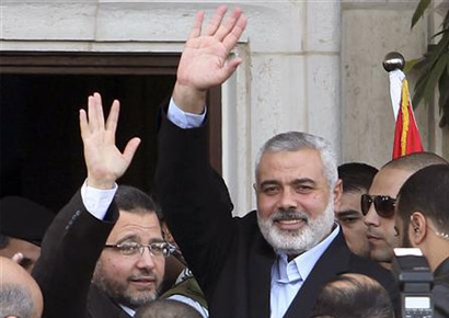 Egyptian prime minister Hisham Kandil (L) and senior Hamas leader Ismail Haniyeh wave to people in Gaza City on Friday.