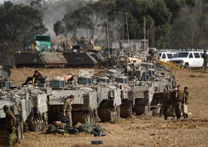 Israeli soldiers prepare armoured personnel carriers (APCs) at an area near the border with the Gaza Strip on Friday.