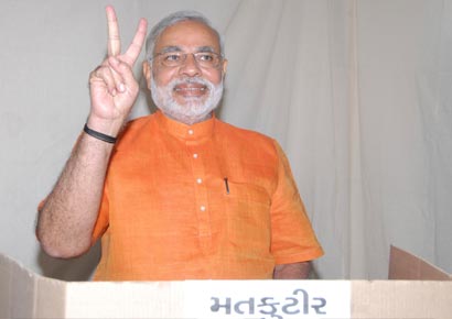 Narendra Modi gestures as he casts his vote during the second phase of state elections in Ahmedabad