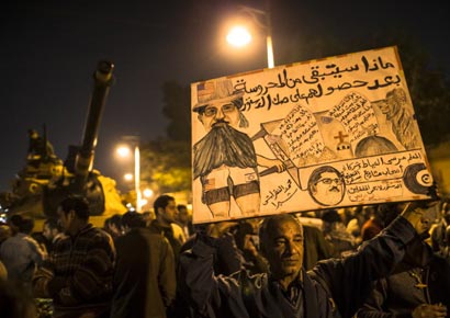 An Egyptian protester opposed to president Mohamed Mursi holds up a placard during a demonstration at the Presidential Palace in Cairo on December 18, 2012.