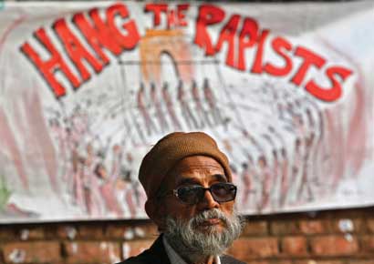 A demonstrator sits in front of a banner as he takes part in a protest against gangrape of 23-year-old woman in New Delhi on Monday.