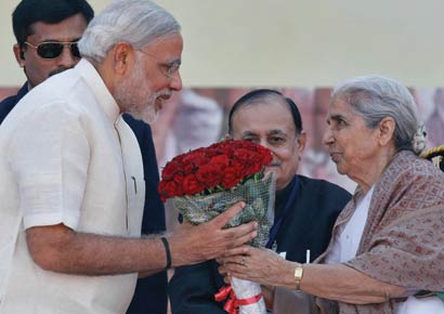 Governor of Gujarat, presents a bouquet to Narendra Modi after he took his oath as chief minister of Gujarat in the swearing-in ceremony