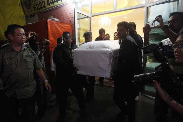 Undertaker Roland Tay (L) and his crew carry the coffin of an Indian rape victim into a van as they leave a funeral parlour for the airport in Singapore.
(Reuters)