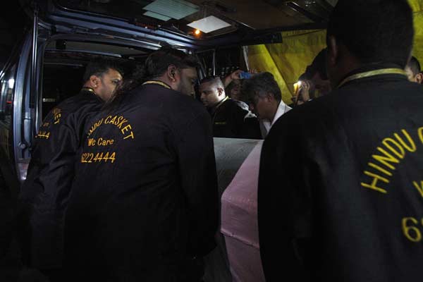 Workers carry the coffin of an Indian rape victim into a van as they leave a funeral parlour for the airport in Singapore.
(Reuters)