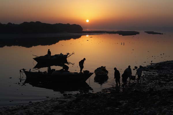 Fishermen are silhouetted against the early morning light as they return from fishing in Karachi's China Creek
Photo by Akhtar Soomro