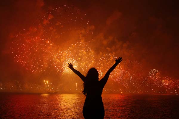 A woman celebrates the New Year as she watches fireworks exploding above Copacabana beach in Rio de Janeiro
Photo by Pilar Olivares