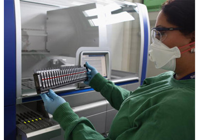 A scientist operates a RT-PCR machine. The polymerase chain reaction is a technique to amplify a single or few copies of a piece of DNA.