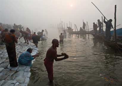 Hindu devotees take a holy dip in the waters of river Ganges amid fog ahead of the Kumbh Mela