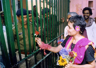 Booker winner and social activist Arundhati Roy presents a flower to the jail guards of Tihar Central Jail after serving a 'symbolic'' one-day sentence for contempt of court, in New Delhi on March 7, 2002.