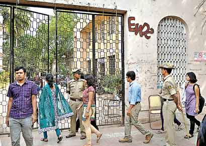Students entering the Bangalore Medical College on Monday as policemen stand guard at the entrance of the institution.