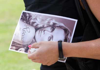 A mourner carries Reeva Steenkamp's picture