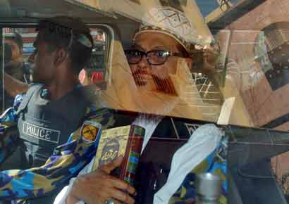 Delwar Hossain Sayedee (R), 73, vice-president of the Jamaat-e-Islami party, sits inside a vehicle next to a police officer on his way to a court in Dhaka, Bangladesh on Thursday. A Bangladesh tribunal sentenced an Islamist party leader to death on Thursday, the third verdict by the court set up to investigate abuses during the country`s independence war, and 15 people were killed in protests by his supporters. Sayedee was found guilty of charges of mass killing, rape, arson, looting and forcing minority Hindus to convert to Islam during the 1971 war of independence from Pakistan.