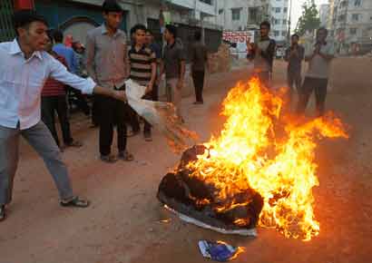 Activists from Bangladesh's Jamaat-e-Islami set fire to a pile of cotton material on a street during a strike to protest against the decision by the country's war crimes tribunal to deliver judgement in the cases involving their top leaders in Dhaka on March 3.