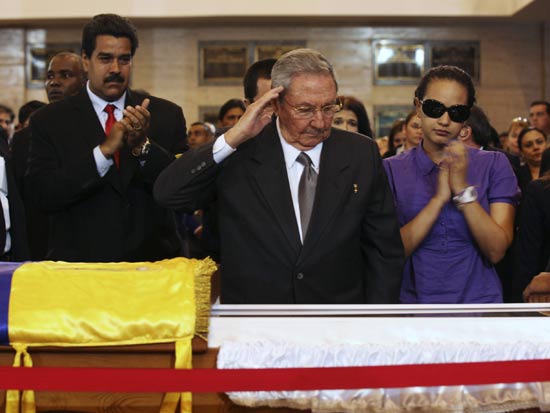 Cuba's President Raul Castro salutes the body of late Venezuelan President Hugo Chavez, which is lying in state, as he visits the wake with Chavez's daughter, Rosa Virginia (R), and Venezuela's Vice-President Nicolas Maduro (2nd L) at the military academy in Caracas March 7, 2013, in this picture provided by the Miraflores Palace. Chavez will be embalmed and put on display 