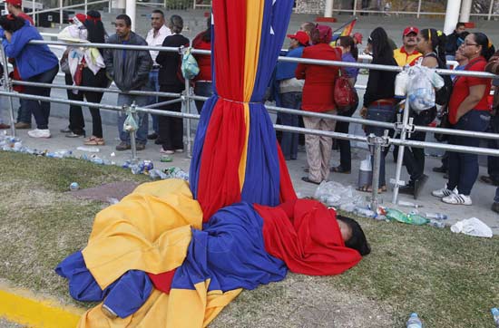A supporter of Venezuela's late President Hugo Chavez sleeps after having spent the entire night waiting for a chance to view his body at the military academy in Caracas March 8, 2013. Chavez will be embalmed and put on display 