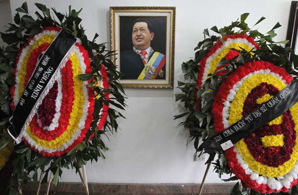 Wreaths from the Chinese embassy (L) and the Qatari embassy (R) are seen next to an image of Venezuela's late President Hugo Chavez at the Venezuelan embassy in Hanoi March 8, 2013. Ending one of Latin America's most remarkable populist rules, Chavez died on Tuesday at age 58 after a two-year battle with cancer that was first detected in his pelvis. 
