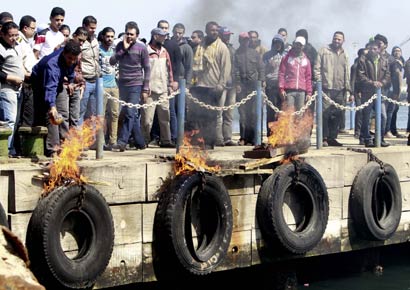 People against Egyptian President Mohamed Mursi burn tyres on the dock near the Suez Canal, in Port Said city.