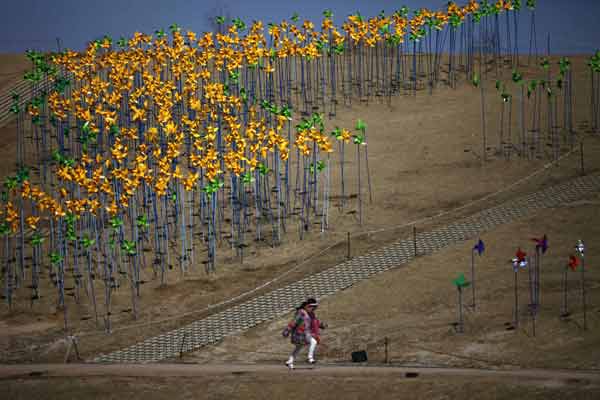 A girl runs past pinwheels arranged in the shape of the Korean peninsula at Imjingak pavillion near the demilitarized zone (DMZ) which separates the two Koreas in Paju, north of Seoul. 