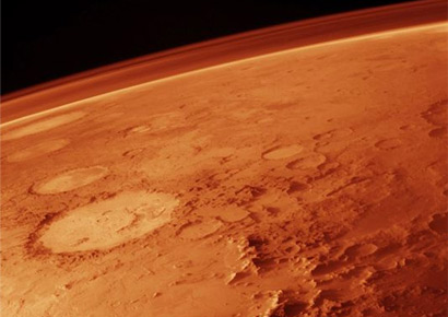 The tenuous atmosphere of Mars, visible on the horizon in this low-orbit photo