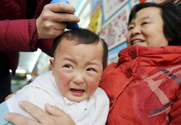 A child cries while getting a haircut at a barber shop in Huaibei, Anhui province.
Photo by China Daily
(Reuters)
