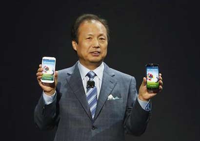 JK Shin, President and Head of IT and Mobile Communication Division, holds up Samsung's latest Galaxy S4 phones during its launch at the Radio City Music Hall in New York.