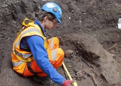 A worker measures the length of a skeleton at the project site.