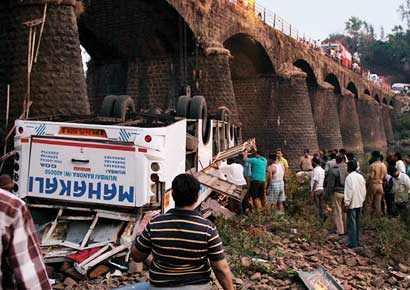 People rescue trapped passengers of the ill-fated Mahakali Travels bus that fell off a bridge over Jagbudi river in Khed area of Ratnagiri district on the Mumbai-Goa highway on Tuesday.