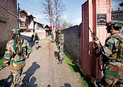 Soldiers take position near the site of a shootout on the outskirts of Srinagar on Thursday.