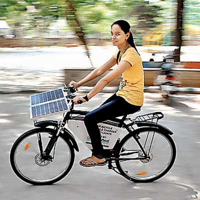 Abigail, a student of Maharani Science College, rides a solar powered cycle that was displayed at the National solar energy convention at Maharani College in Bangalore on Tuesday