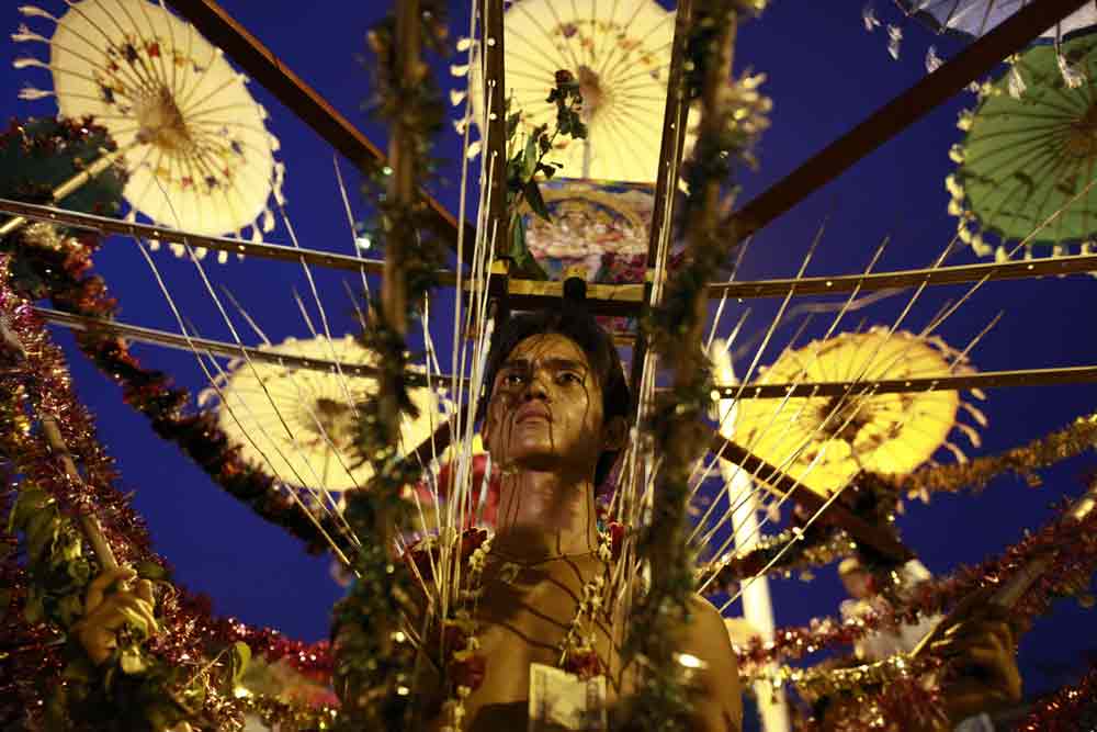 A Hindu devotee wearing a kavadi walks on hot coal during the anniversary celebrations of a Hindu temple in Yangon. Photo by Soe Zeya Tun