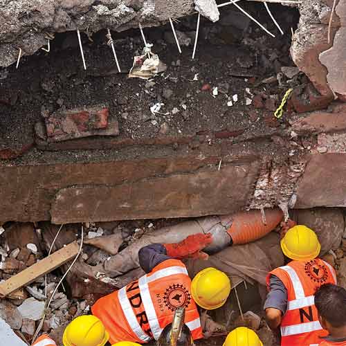Rescue workers pull out a body from the debris of the building that collapsed at Arihant Compound in Bhiwandi on Thursday.