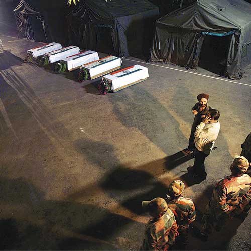 Indian Army soldiers stand near the coffins of their colleagues during a wreath laying ceremony in Poonch district on Tuesday.