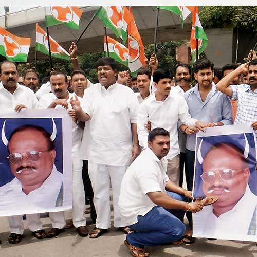 Protest against the remarks of JD(S) man M Srinivas by defacing his portrait and hitting it with footwear.