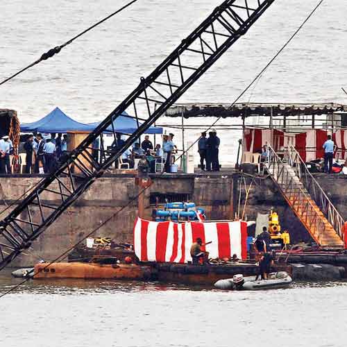 Naval divers are seen on board an inflatable craft next to the submerged INS Sindhurakshak in Mumbai on Friday.