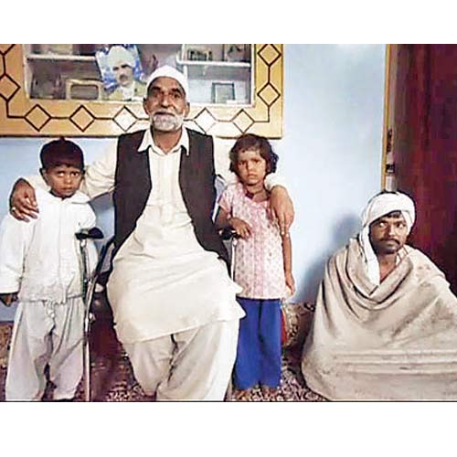 Mushtaq Ahmed Shah, a cousin of Ghulam Qadir Shah, with Kalu Ram and the two children who were stranded in Kishtwar town.