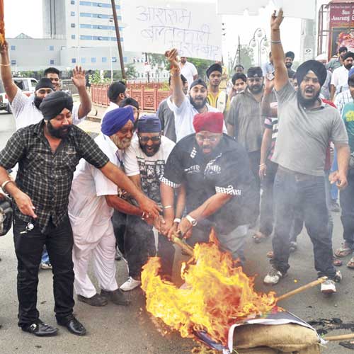 Sikh community members burn an effigy of Asaram Bapu on Sunday.