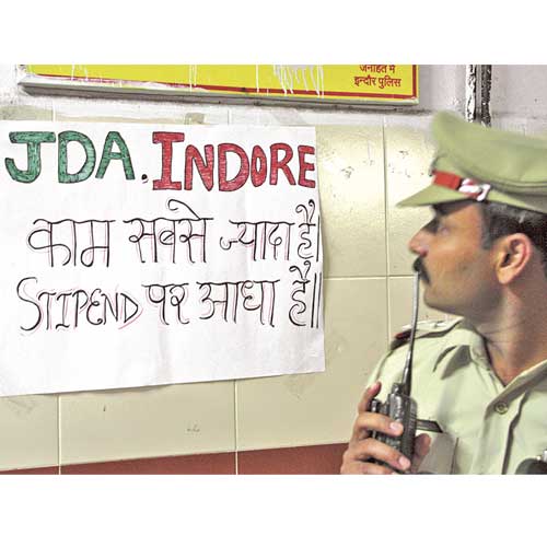 A policeman looks at a poster pasted by junior doctors at MY Hospital on Thursday.