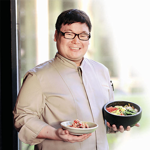 Chef Cha holding kimchi salad and Rice Bibimbap