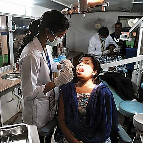 A dentist examines a patient at the Healthex International 2013 exhibition on hospital, medical and surgical equipment at Bangalore International Exhibition Centre on Thursday.