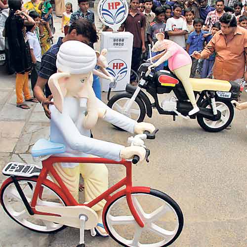 Lord Ganesha is shown riding a bicycle signifying the impact of rising fuel prices.