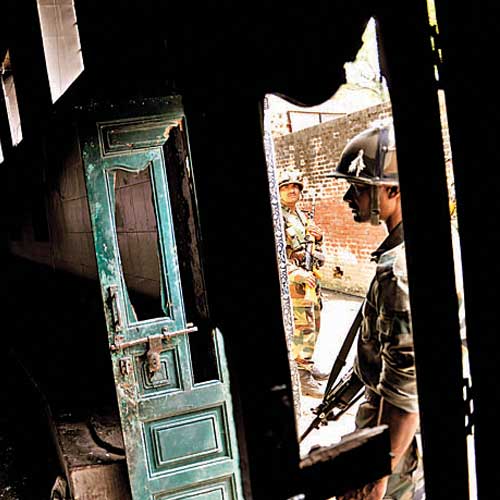 An army personnel checks inside a burnt masjid in Kudba village of Muzaffarnagar on Wednesday.