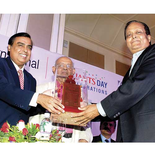 Chief guest Mukesh Ambani presents an award to Ramesh Chandra Agarwal, owner of Dainik Bhaskar Group, for his contribution to the field of journalism, on Tuesday.