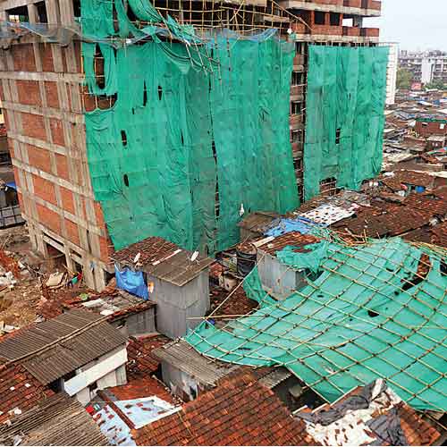 The scaffolding, erected to construct an SRA building, lies over 30 hutments in Dharavi after it fell on Thursday.